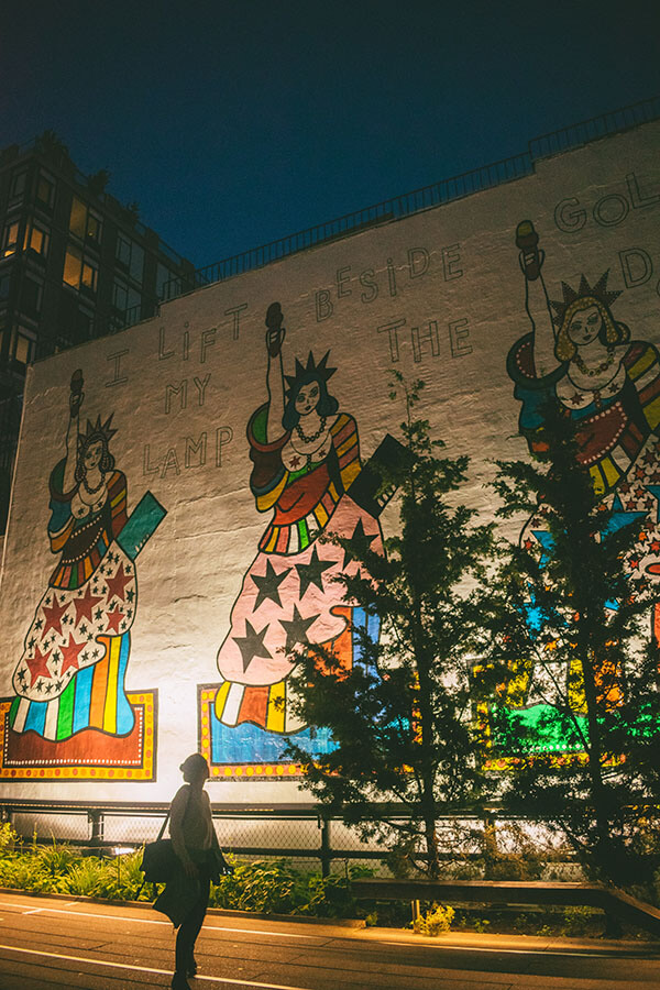 Girl admiring art with the Statue of Liberty along the Highline, one of the best free places in New York to enjoy. 