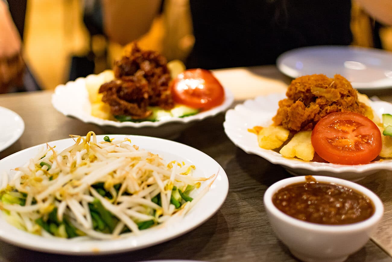 A delicious Javanese Surinamese meal shared among friends at a Surinamese restaurant in the Hague. Read about the best Surinamese food try in the Netherlands.