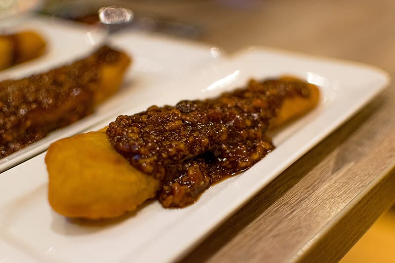 Delicious fried banana with peanut sauce (Bakabana), a traditional Surinamese snack.