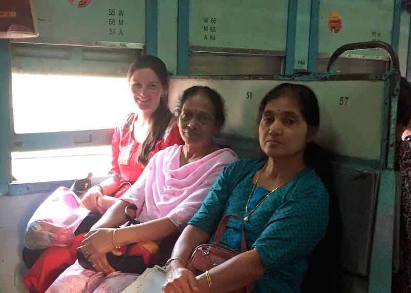 Woman with new local friends during a train trip, one of the ways to meet locals while traveling